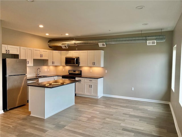 kitchen with sink, white cabinets, and appliances with stainless steel finishes