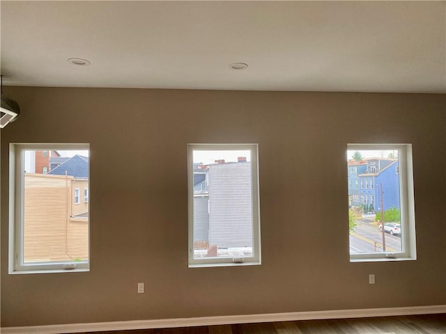 unfurnished room featuring hardwood / wood-style flooring and a healthy amount of sunlight