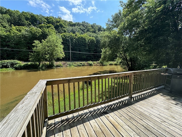 wooden deck with a yard and a water view