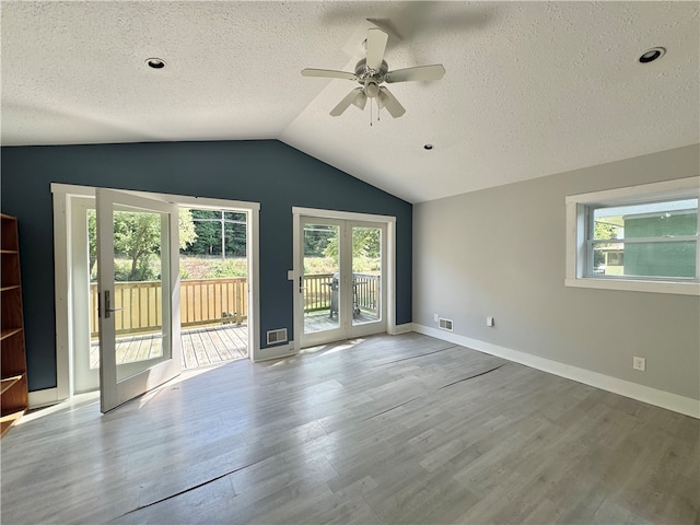 interior space featuring lofted ceiling, a textured ceiling, hardwood / wood-style floors, and ceiling fan