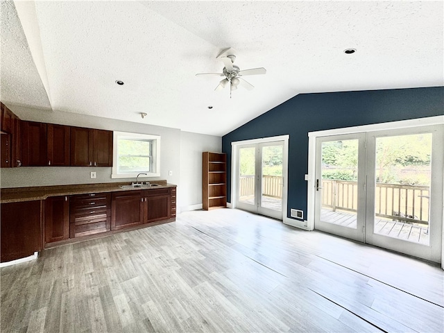 kitchen with plenty of natural light, ceiling fan, light hardwood / wood-style flooring, and lofted ceiling