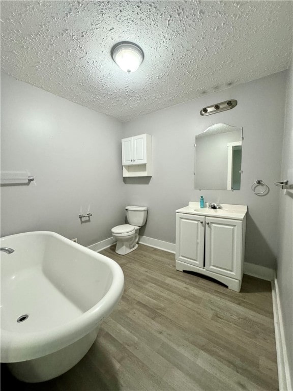 bathroom featuring vanity, a textured ceiling, wood-type flooring, and toilet