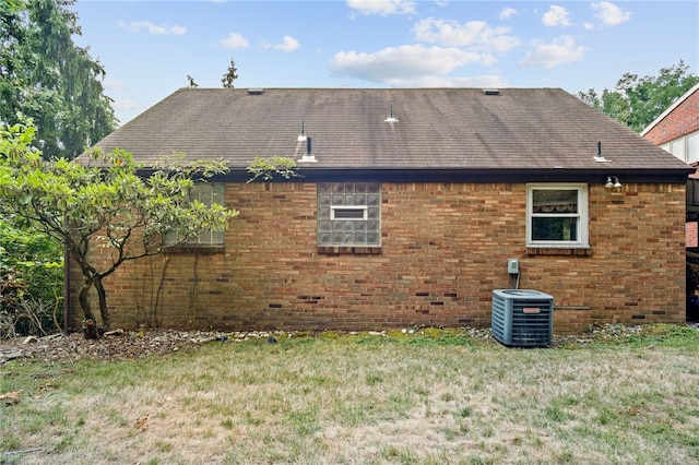 rear view of house featuring a yard and cooling unit