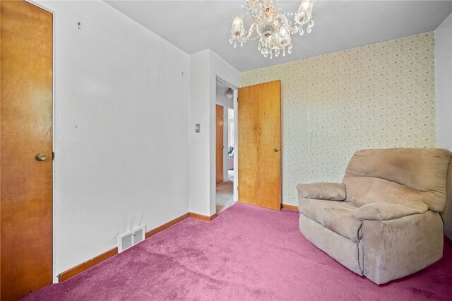 sitting room featuring carpet floors and an inviting chandelier