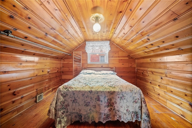 unfurnished bedroom featuring wooden ceiling, wooden walls, wood-type flooring, and vaulted ceiling