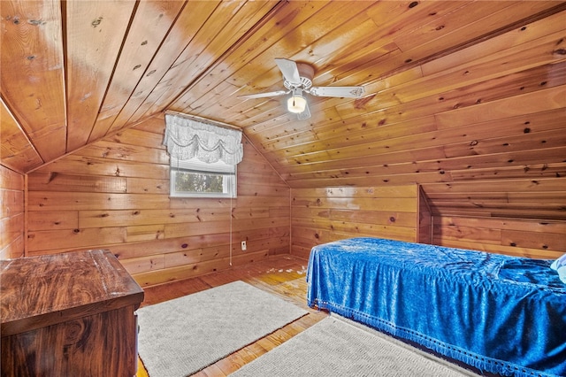 bedroom with wood ceiling, wood walls, wood-type flooring, and vaulted ceiling