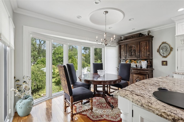 dining space with a healthy amount of sunlight, crown molding, and light wood-type flooring