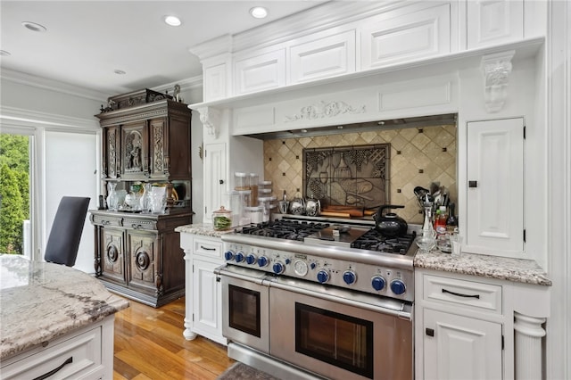 kitchen with double oven range, white cabinetry, and a healthy amount of sunlight