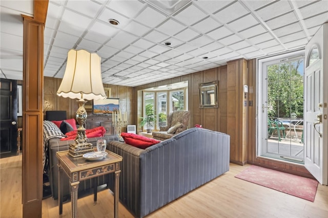 living room featuring wood walls, plenty of natural light, and light hardwood / wood-style floors