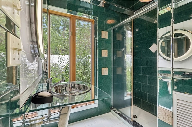 bathroom featuring tile walls, a shower with shower door, and sink