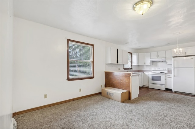 kitchen with plenty of natural light, sink, white appliances, and carpet flooring