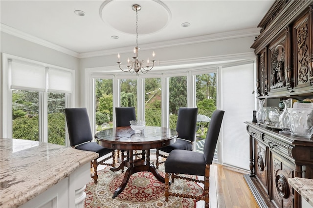 dining space with a notable chandelier, light hardwood / wood-style flooring, and crown molding