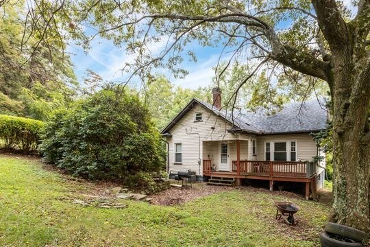 rear view of property with a yard and a deck