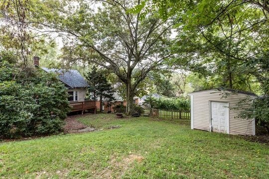 view of yard featuring a wooden deck and a storage shed