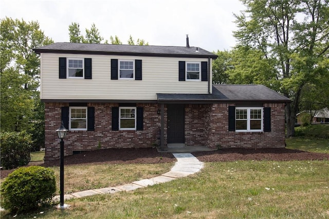 view of front of house featuring brick siding and a front lawn