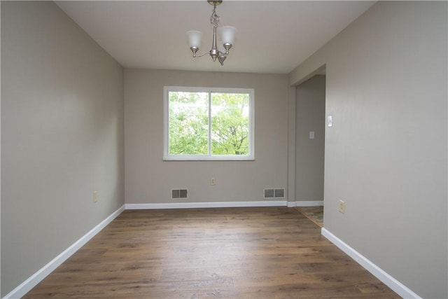 unfurnished dining area featuring visible vents, baseboards, and wood finished floors