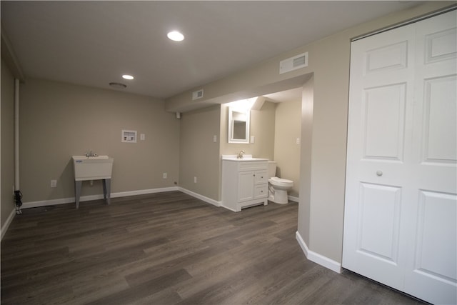 interior space featuring a sink, visible vents, recessed lighting, and dark wood-style flooring