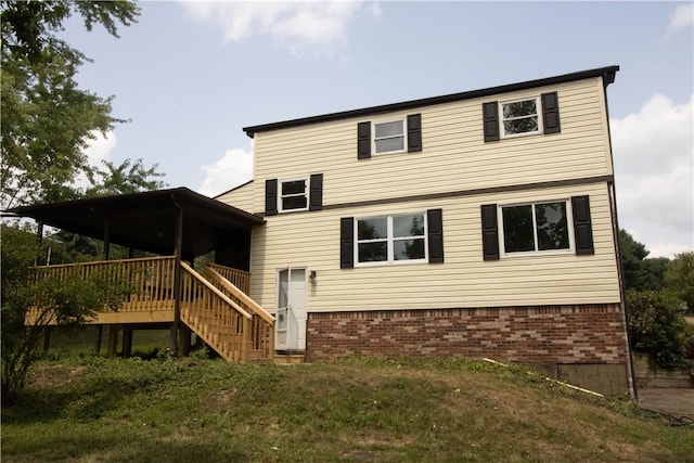 rear view of house featuring a wooden deck, brick siding, and stairs