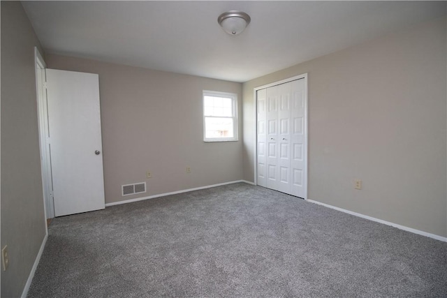 unfurnished bedroom with visible vents, baseboards, carpet, and a closet