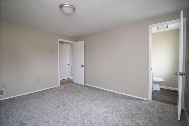 unfurnished bedroom featuring carpet flooring, baseboards, visible vents, and ensuite bathroom