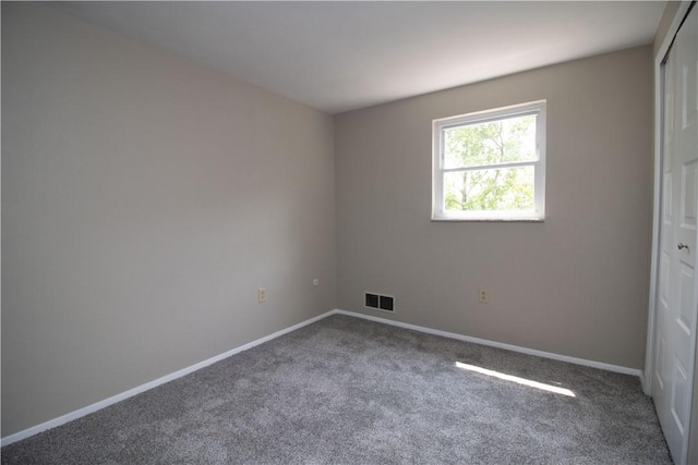 unfurnished bedroom featuring visible vents, baseboards, carpet floors, and a closet