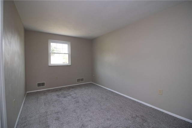 unfurnished room with visible vents, baseboards, and carpet