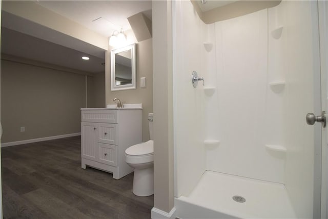 full bath featuring baseboards, toilet, a stall shower, wood finished floors, and vanity