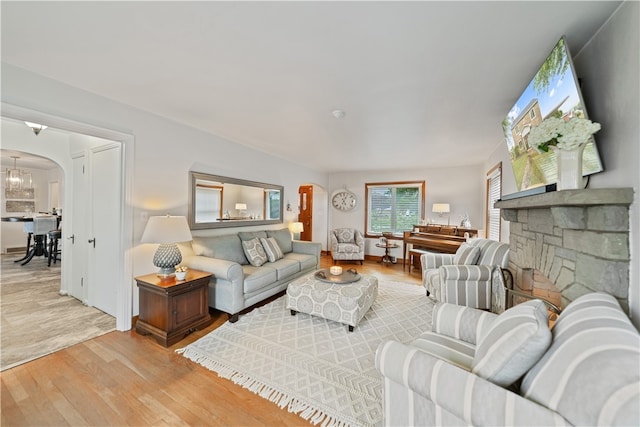 living room with hardwood / wood-style floors and a stone fireplace