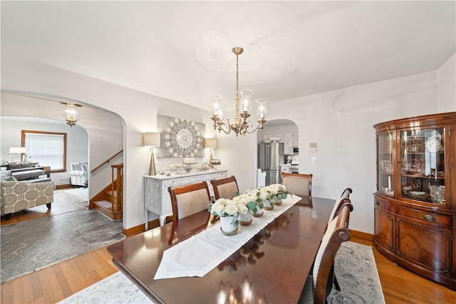 dining room with hardwood / wood-style floors and an inviting chandelier