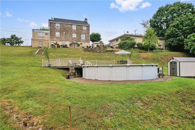 view of yard with a storage unit and a pool side deck