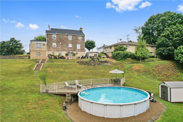 view of swimming pool with a shed, a deck, and a lawn