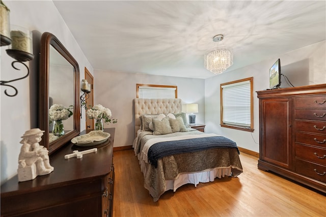 bedroom featuring light hardwood / wood-style floors and a notable chandelier