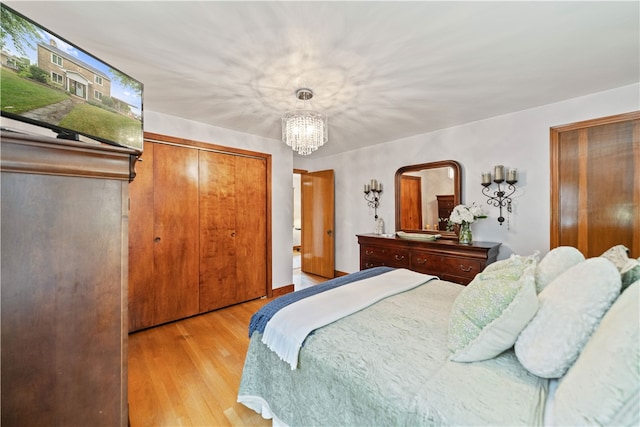 bedroom featuring a notable chandelier, a closet, and light hardwood / wood-style flooring