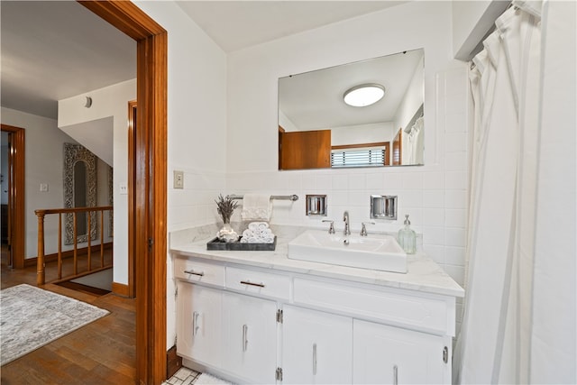 bathroom featuring vanity, hardwood / wood-style flooring, and backsplash