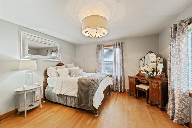 bedroom with hardwood / wood-style floors and a notable chandelier