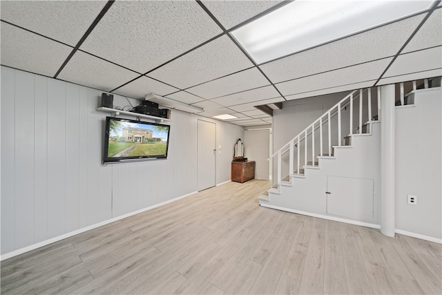 basement featuring a drop ceiling and wood-type flooring