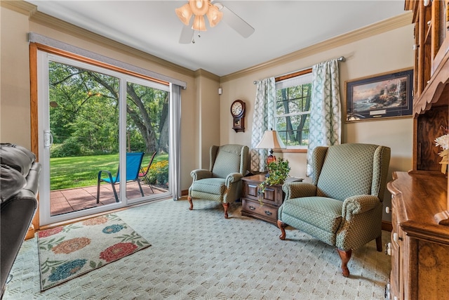 sitting room featuring ceiling fan, ornamental molding, carpet floors, and plenty of natural light