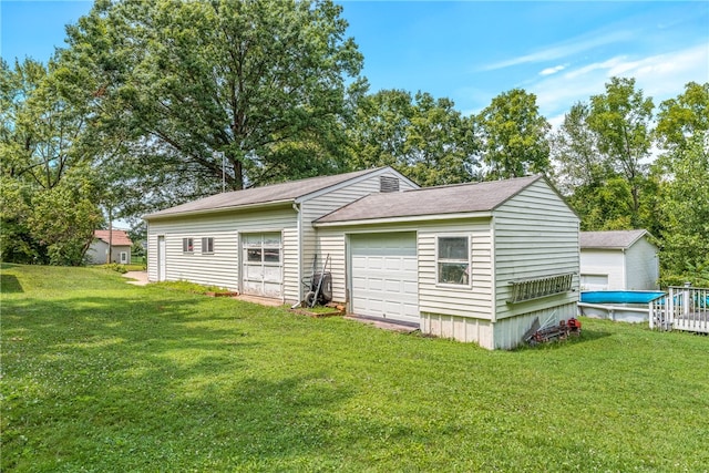 rear view of property with a garage and a yard