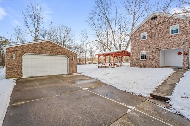 snowy yard with a garage and an outdoor structure