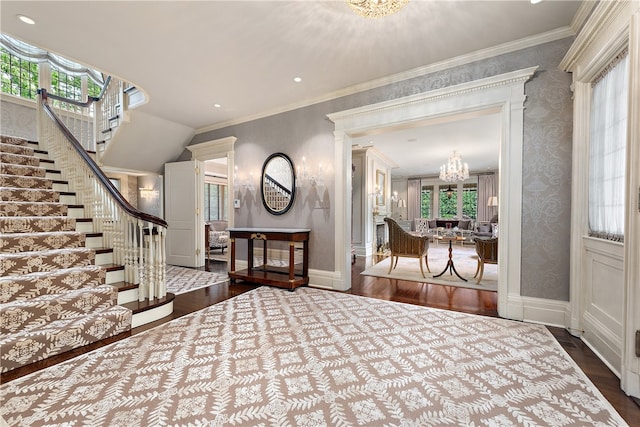 entrance foyer featuring a notable chandelier, wood-type flooring, and crown molding