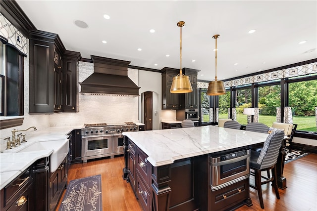 kitchen with appliances with stainless steel finishes, backsplash, crown molding, light wood-type flooring, and custom range hood