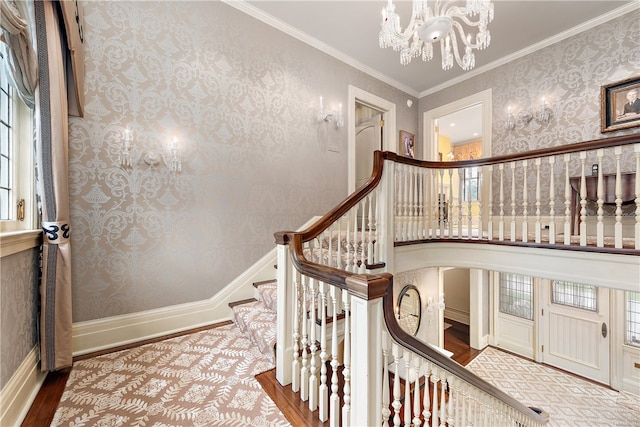 stairs featuring a chandelier, light wood-type flooring, and ornamental molding