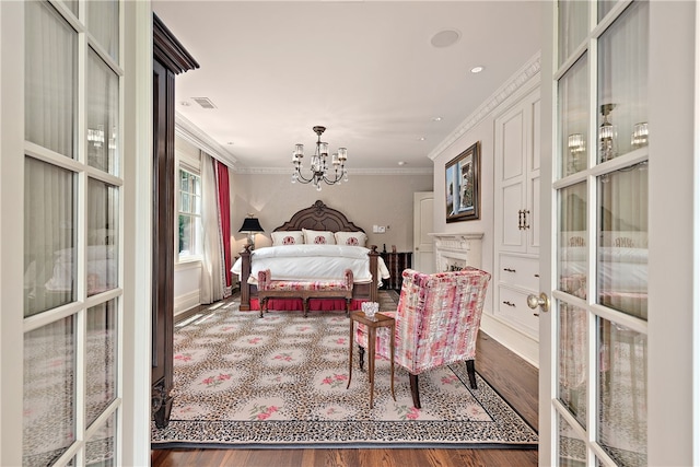 bedroom featuring dark wood-type flooring, french doors, crown molding, and a notable chandelier