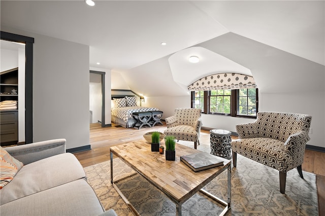 living room featuring lofted ceiling and light hardwood / wood-style floors