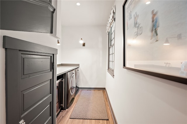 laundry room with light wood-type flooring and separate washer and dryer