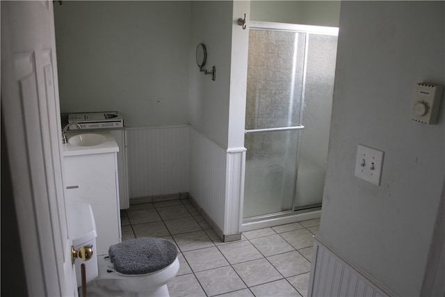 bathroom with toilet, vanity, tile patterned flooring, and an enclosed shower