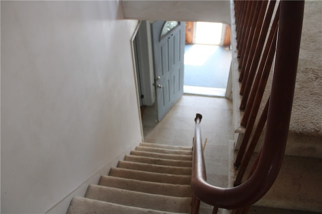 staircase featuring light tile patterned floors