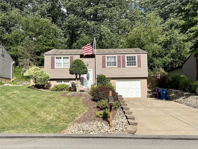 raised ranch featuring a garage and a front lawn