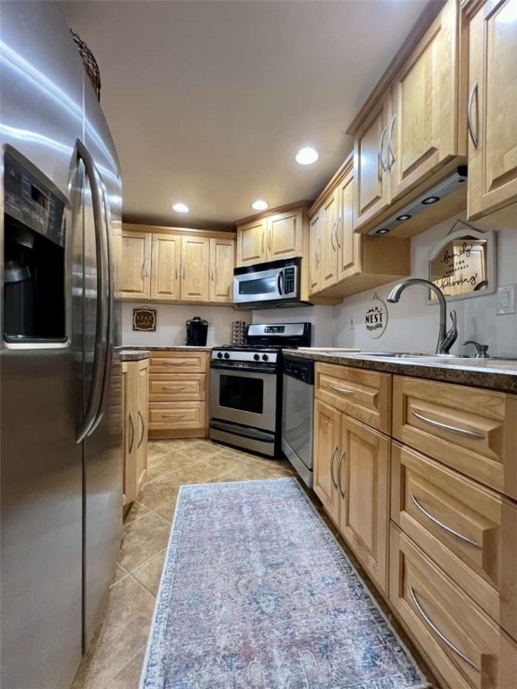 kitchen with light tile patterned flooring, sink, light brown cabinets, and stainless steel appliances