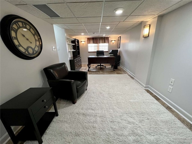 living room featuring carpet floors and a paneled ceiling